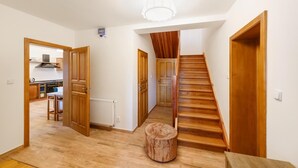 Un couloir doté d’un plancher en bois, d’un escalier en bois et d’un radiateur.