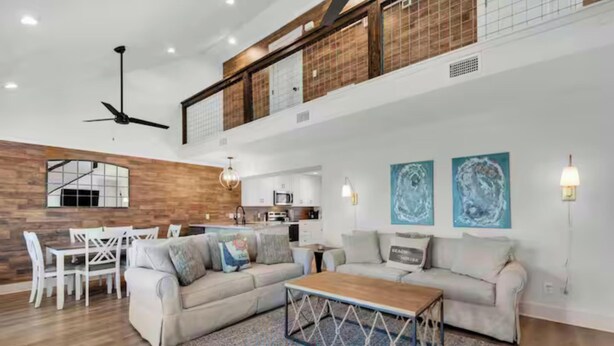 A spacious living area with a high ceiling, a dining set, and a kitchen in the background. - Steps to the Beach 3BR Coastal Home Sleeps 10 (Port Saint Joe)