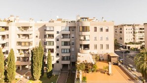 A multi-story residential building with balconies, a courtyard, and a street view. - [PENTHOUSE ROME- 5 stars] elegant apartment (Roma)