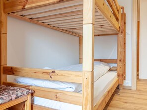 Cozy sleeping quarters with a main bed and lower bunk, featuring a simple design and ample space.