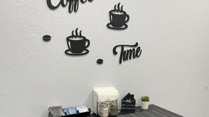 Et lille spiseområde med et bord, to barstole, dekoration med kaffetema og et skilt med teksten "Coffee Time".