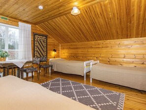 A cozy cabin with two beds, a dining area with a table and chairs, and a large window. - Myllylä by Interhome (Virrat)
