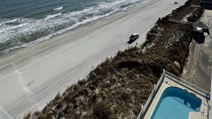 A beach view with a swimming pool and a lifeguard tower. - Oceanfront Condo in Garden City Beach!!!! (murrells inlet)