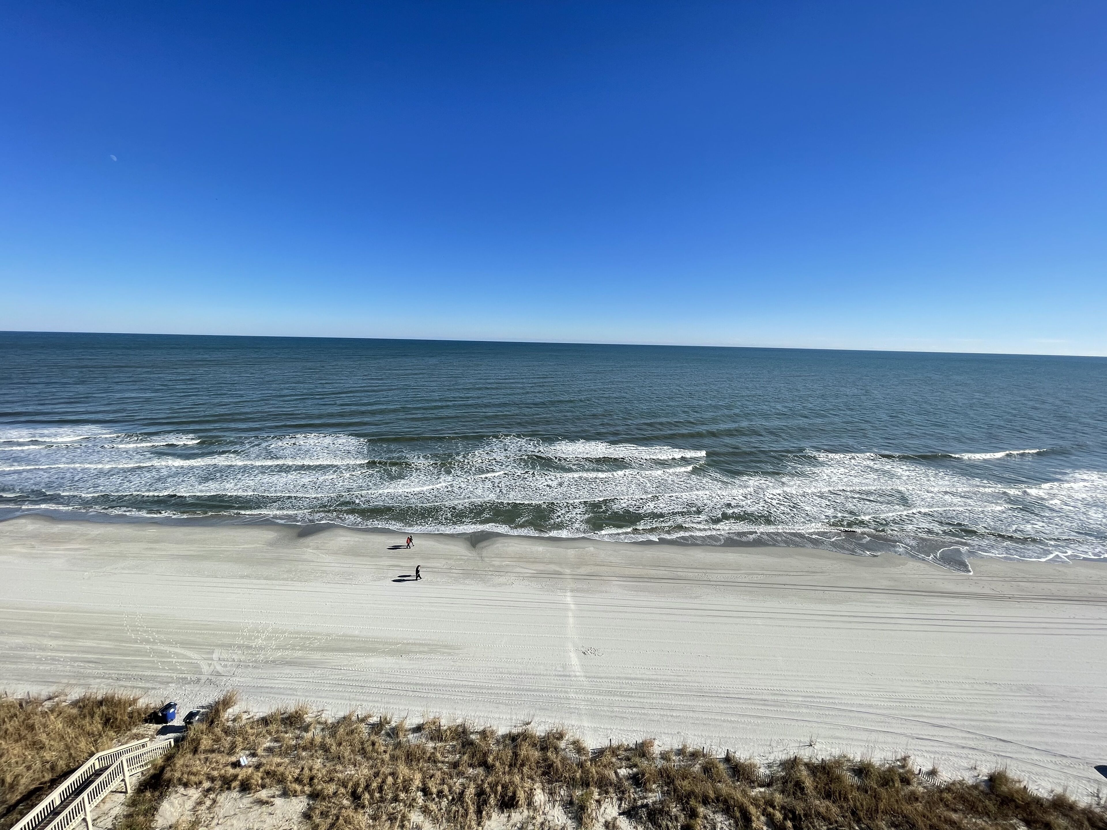 A beach with a sandy shore and waves.