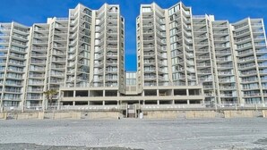 A modern high-rise building with multiple balconies and a central entrance. - Oceanfront Condo in Garden City Beach!!!! (murrells inlet)