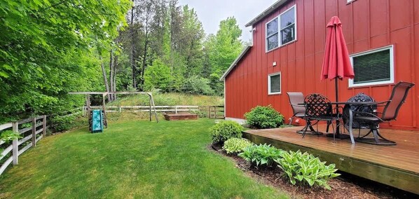 A red building with a deck and outdoor seating area.