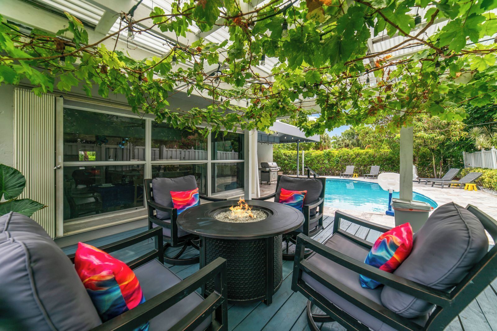 Une terrasse extérieure avec une table ronde, des chaises et un foyer.