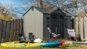 A kayak and chairs in front of a shed. - Private Lakefront House with Hot Tub, Kayaks and Beach (Selkirk)