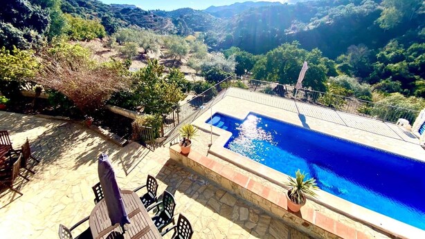 Zona de piscina con vista a un paisaje montañoso.