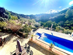 Ein Poolbereich mit Blick auf eine gebirgige Landschaft.