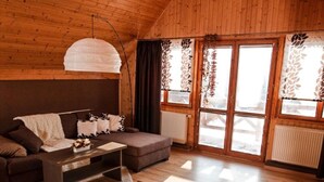 A cozy wooden interior with a sofa, coffee table, and dining table. - Star Hamry Mosl590 (Staré Hamry)