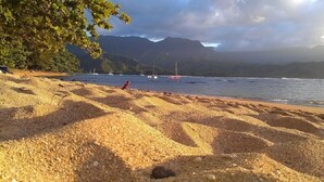 Una playa de piedras con un bote en el agua.