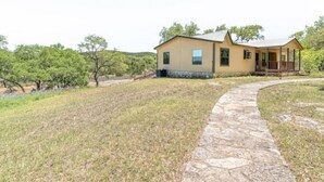 Una casa de un piso con un camino de piedra que lleva a la puerta principal.