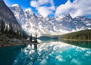 Eine Berglandschaft mit einem klaren See, der die Berggipfel spiegelt.