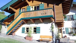 A traditional chalet with a wooden exterior, a balcony, and a stone staircase leading to the entrance. - Apartment Bergzeit- 2 Per. 42sqm, 1 bedroom, wood stove, balcony, WLAN (Oberwössen)