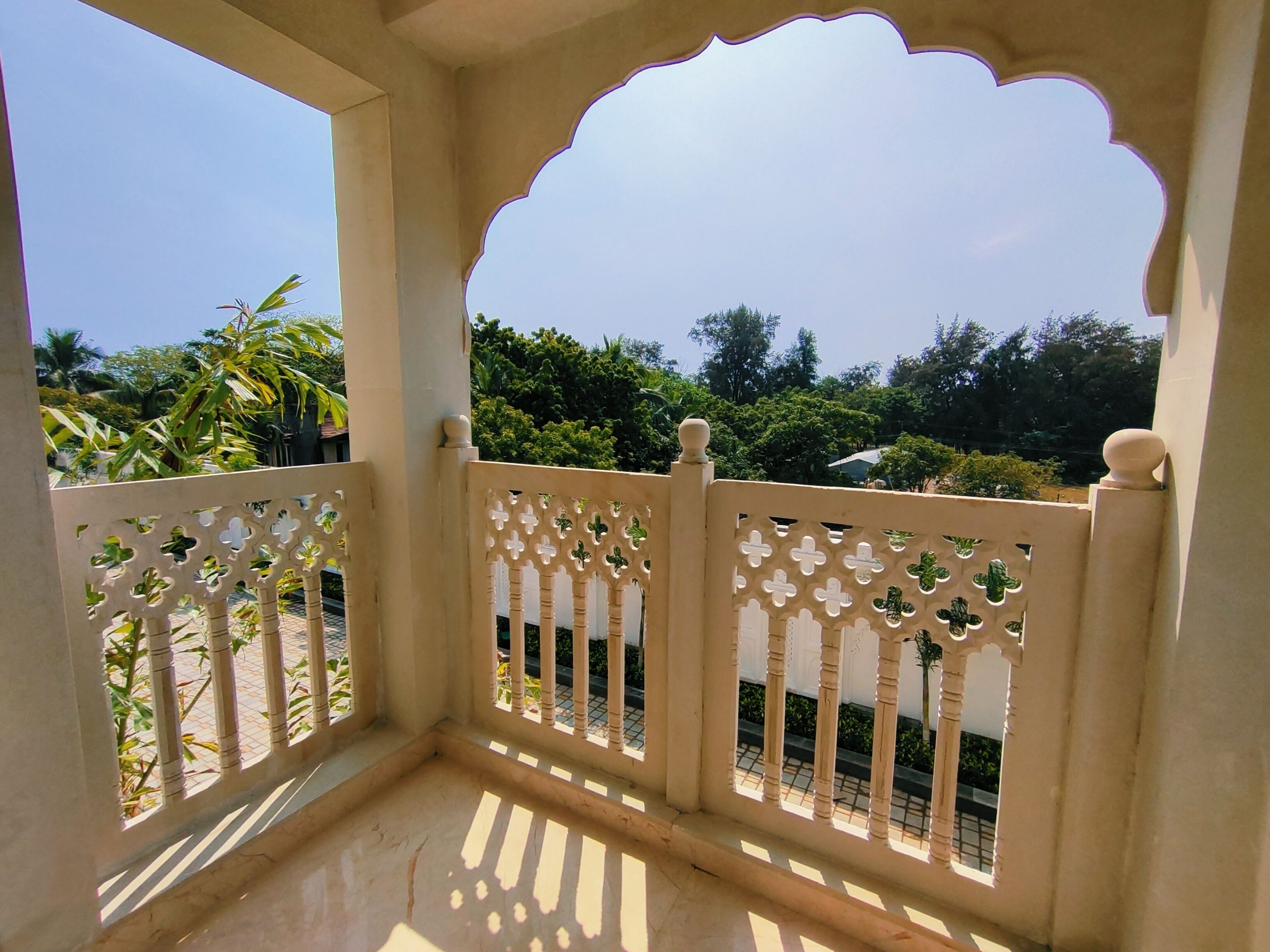 A balcony with a white railing and a decorative arch.