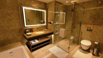 A modern bathroom with a glass-enclosed shower, a large mirror, and a bathtub.