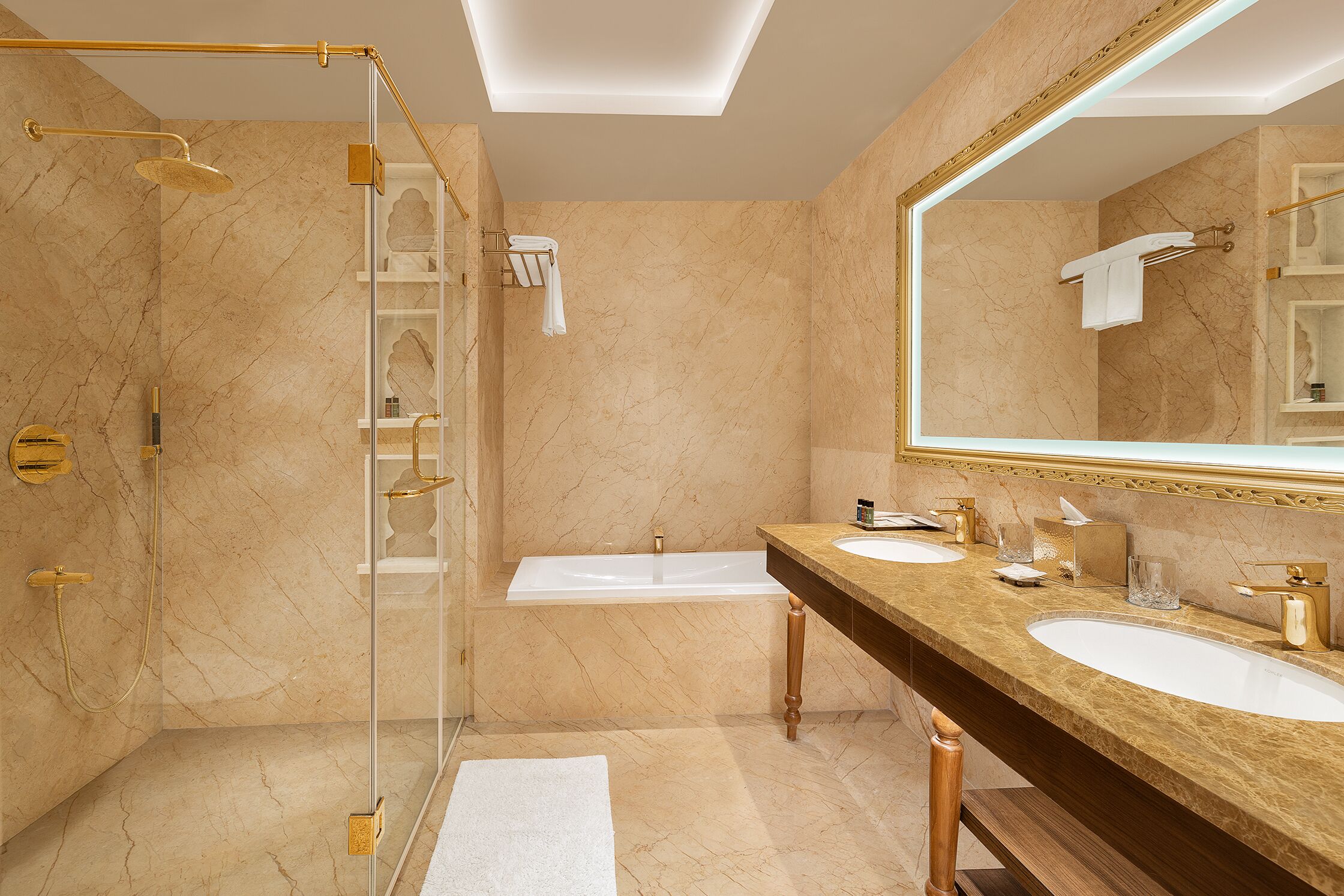 Une salle de bain dotée d’une douche à parois de verre, d’une baignoire et d’un meuble-lavabo avec deux vasques.