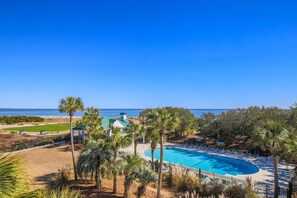 A resort with a pool, palm trees, and a view of the ocean. - Ocean Views, Two Master Suites, Screened Porch & Access to Ocean Point Community Pool & Cabana (Isle of Palms)