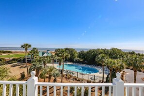 Enjoy ocean views from this beachfront property, featuring a pool, lounge chairs, and a gazebo.