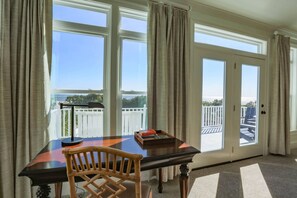 Enjoy a room with a balcony offering a view of the sea, featuring a table, chair, and side table.