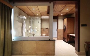 Une salle de bain moderne avec une douche à parois de verre, un meuble-lavabo en bois et un grand miroir.