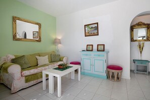 Un salon avec un canapé, une table, un meuble et un miroir.