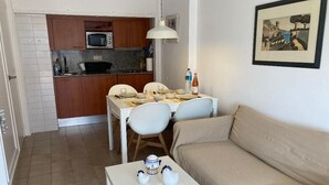 A compact living space with a kitchenette, dining area, and a sofa. - Sunny 2-Bedroom Apartment with Terrace - shared Pool, Parking - Mountain View and close to the Beach (Tossa De Mar)