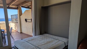 Une chambre à coucher avec un lit, une fenêtre et une vue sur la mer.