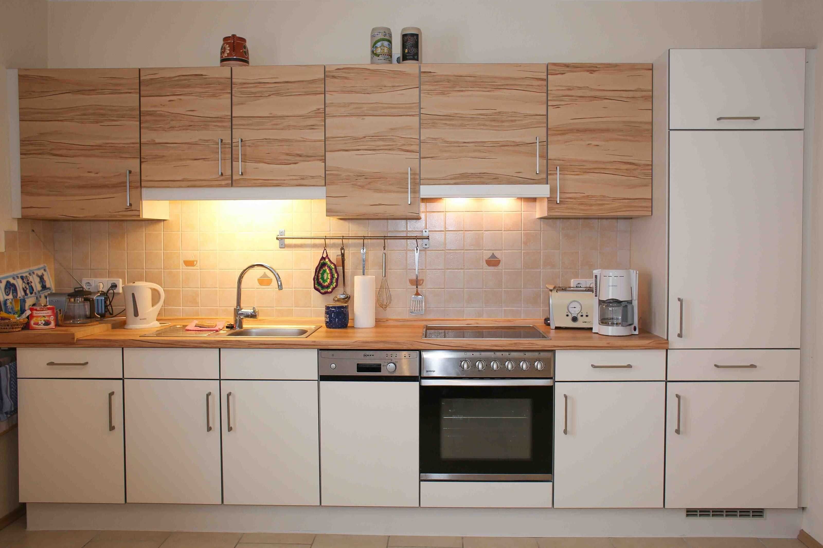 Una cucina con mobili in legno, lavastoviglie, forno, macchina del caffè e tostapane.