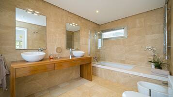 Une salle de bain moderne avec un grand lavabo, une baignoire et un miroir.