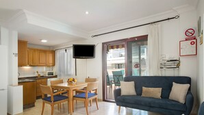 Un apartament modern amb cuina, zona de menjador i saló.