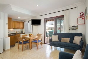 Un appartement moderne comprenant une cuisine, un coin repas et un salon.
