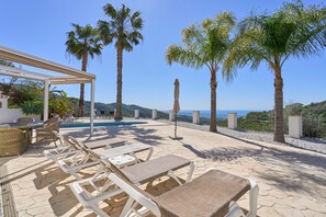 A poolside area with lounge chairs, a pergola, and palm trees. - Villa 'Stunning  Near Velez-malaga' with Sea View, Wi-Fi and Air Conditioning (Arenas)