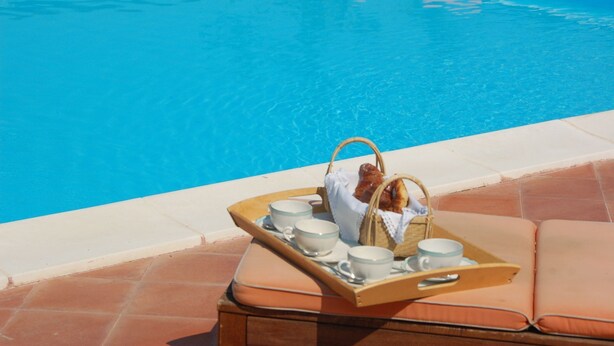 A poolside setting with a tray of cups and a basket, suggesting a relaxing environment. - Villa in Lazio with Pool and Vineyards (Magliano Sabina)