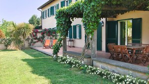 A house with a garden, outdoor seating, and a pergola covered in vines. - Villa in Lazio with Pool and Vineyards (Magliano Sabina)