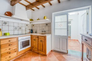 Cozinha com armários de madeira, fogão branco e painel de azulejos.