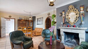 Un salón con sillones de cuero, una chimenea y un espejo en la pared.