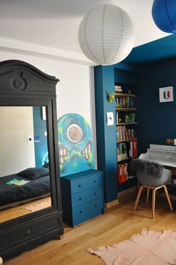 A bedroom with a bed, a dresser, a bookshelf, and a desk with a chair.