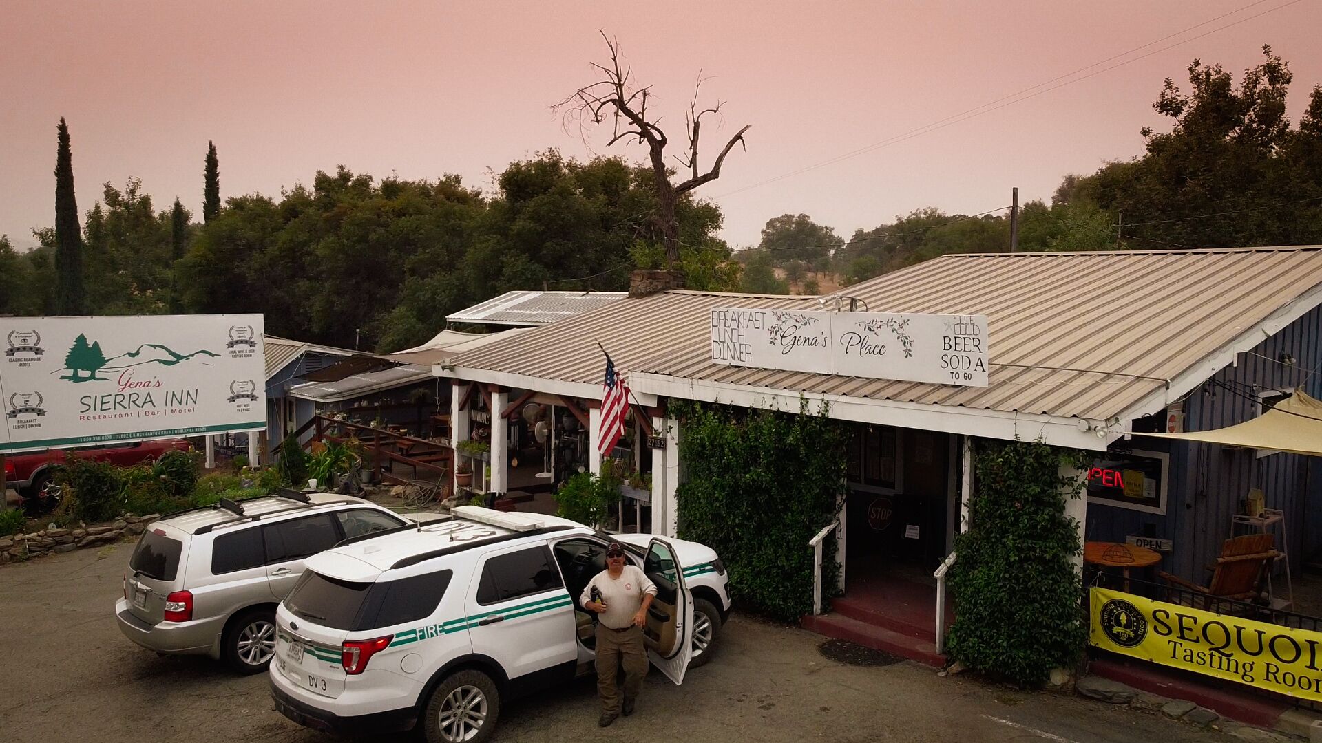 Un edificio con un letrero que dice 'Gena's Sierra Inn Restaurant | Bar | Motel'.