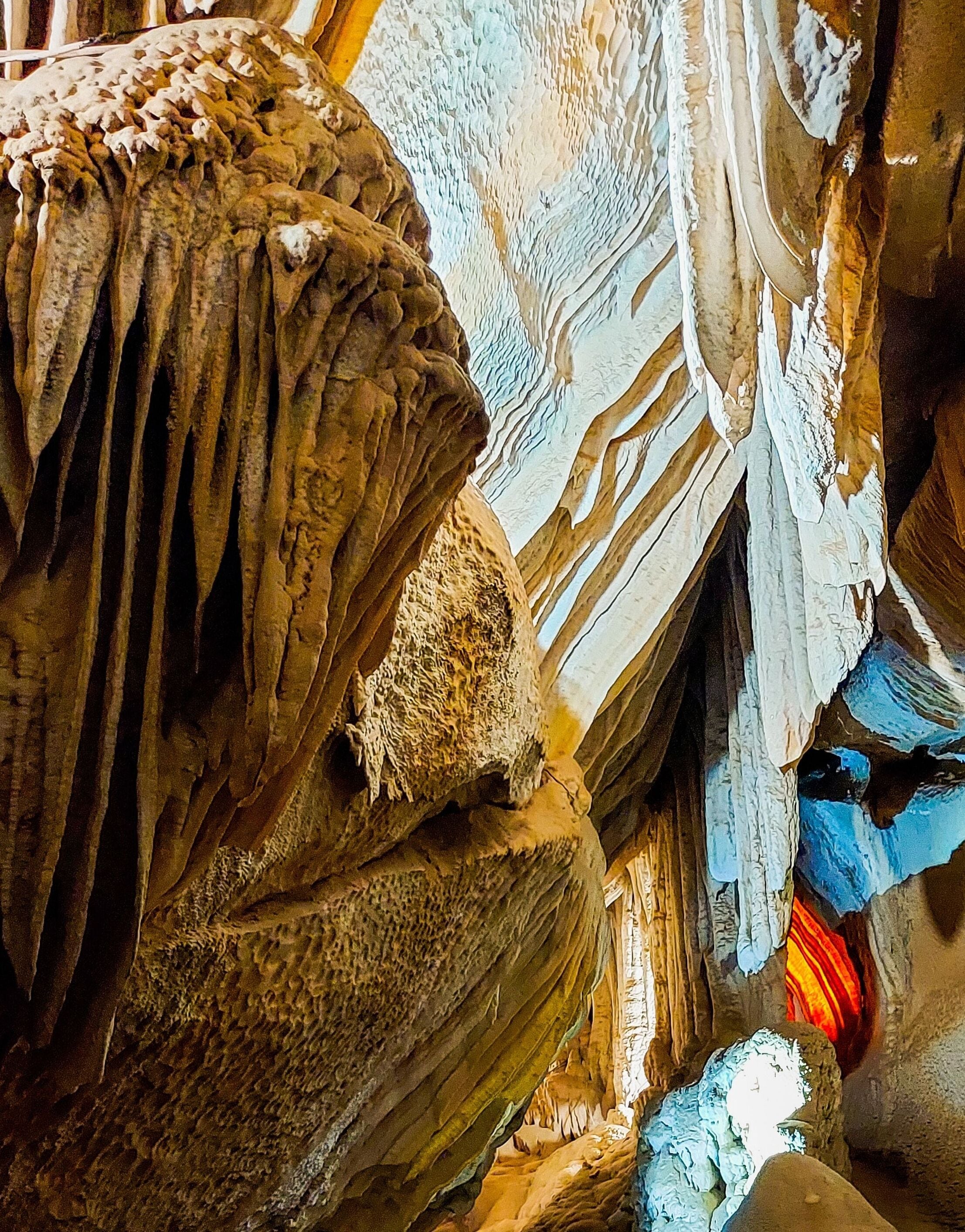 A detailed view of a cave's interior with stalactites and stalagmites.