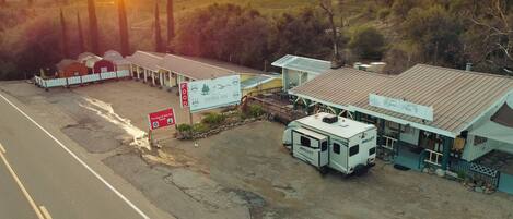A motel with a dining area, a sign for tire chains & snow play rentals, and a trailer parked in front.