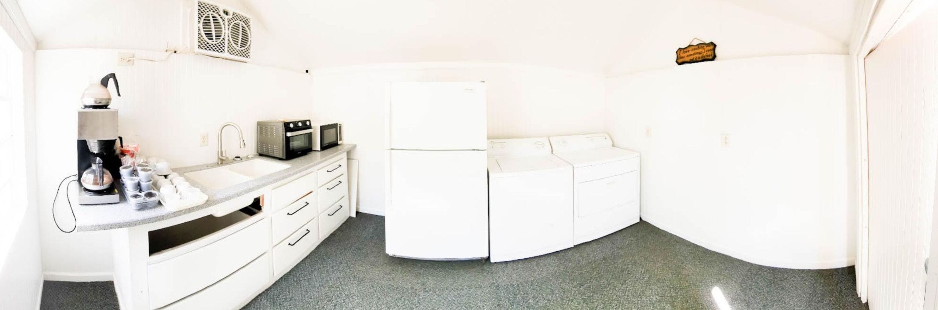 A compact kitchen with a sink, microwave, and refrigerator.