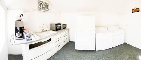 A compact kitchen with a sink, microwave, and refrigerator.