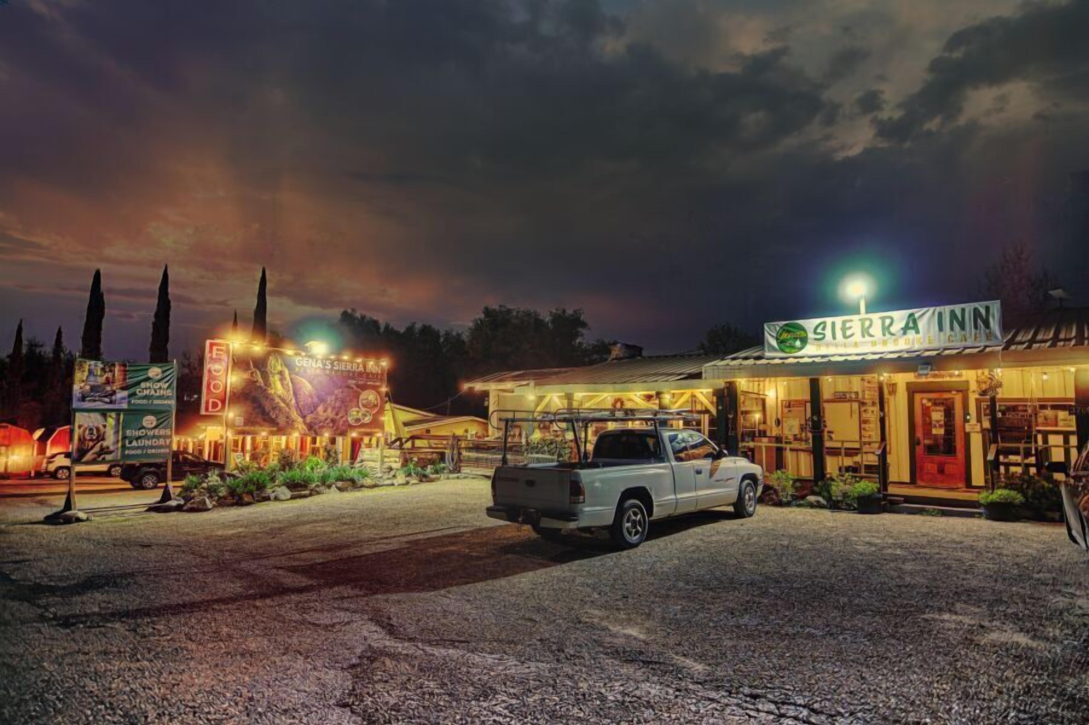 A Sierra Inn with a well-lit entrance, a parking area, and a truck parked in front.