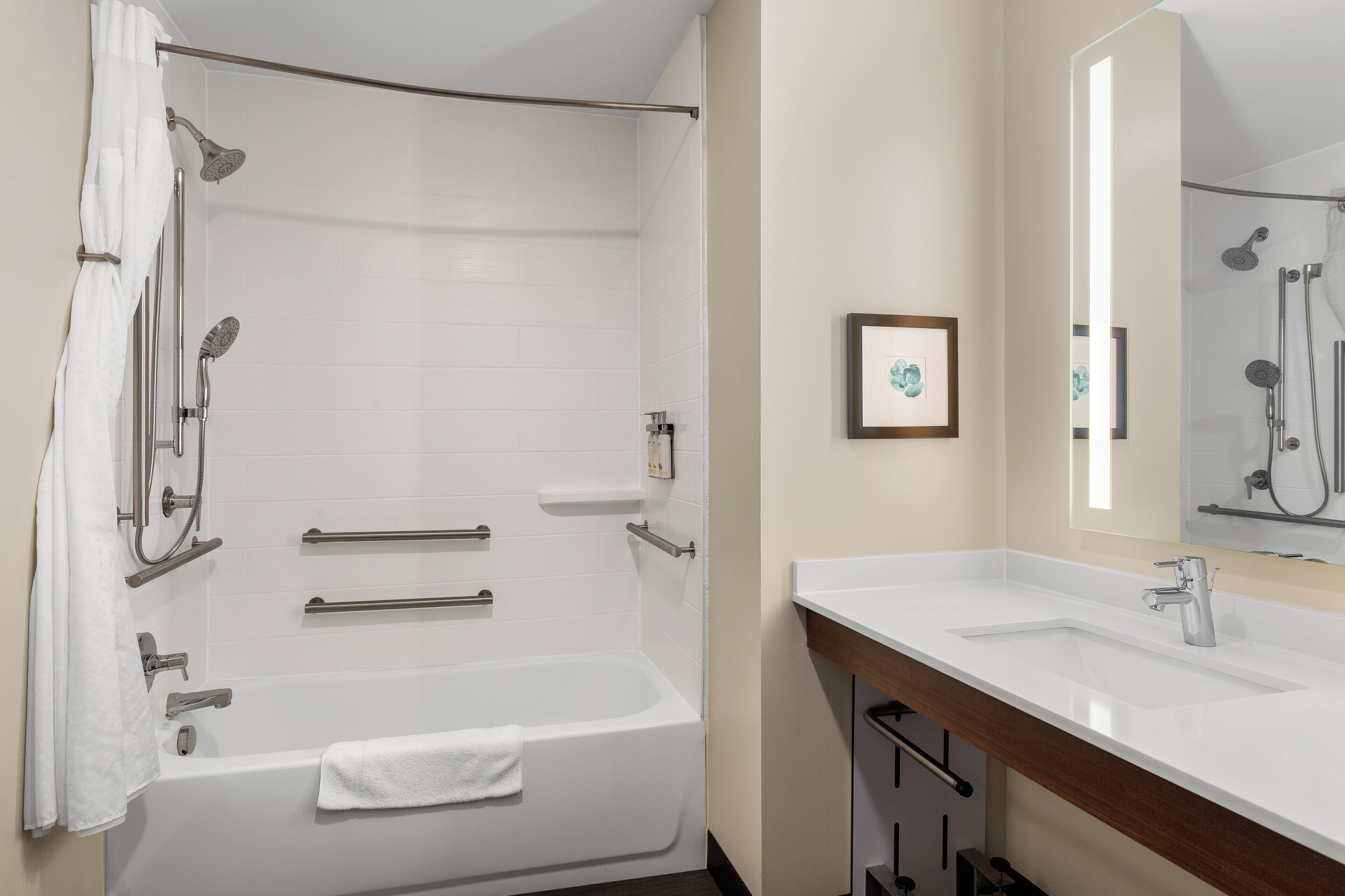A modern bathroom with a bathtub, shower, and vanity.