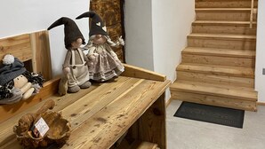 A wooden bench with plush toys and a rustic wall.
