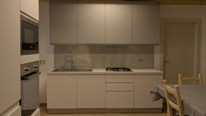 A compact kitchen with a built-in oven, a gas stove, and a sink.