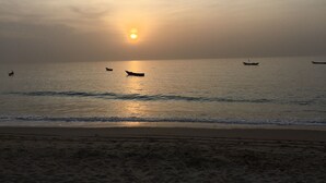 A beach with boats on the water and the sun setting in the background. - VILLA 4 bedrooms facing the sea swimming pool garden terrace parking comfort for 12 (M'Bour)