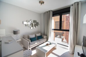 A modern living room with a sofa, coffee table, and a dining area. - M (JMC 5) BERNABEU R. MADRID STADIUM APARTMENT 1 ROOM 2 PAX PARKING  - MADRID BUSINESS CENTER (Madrid)